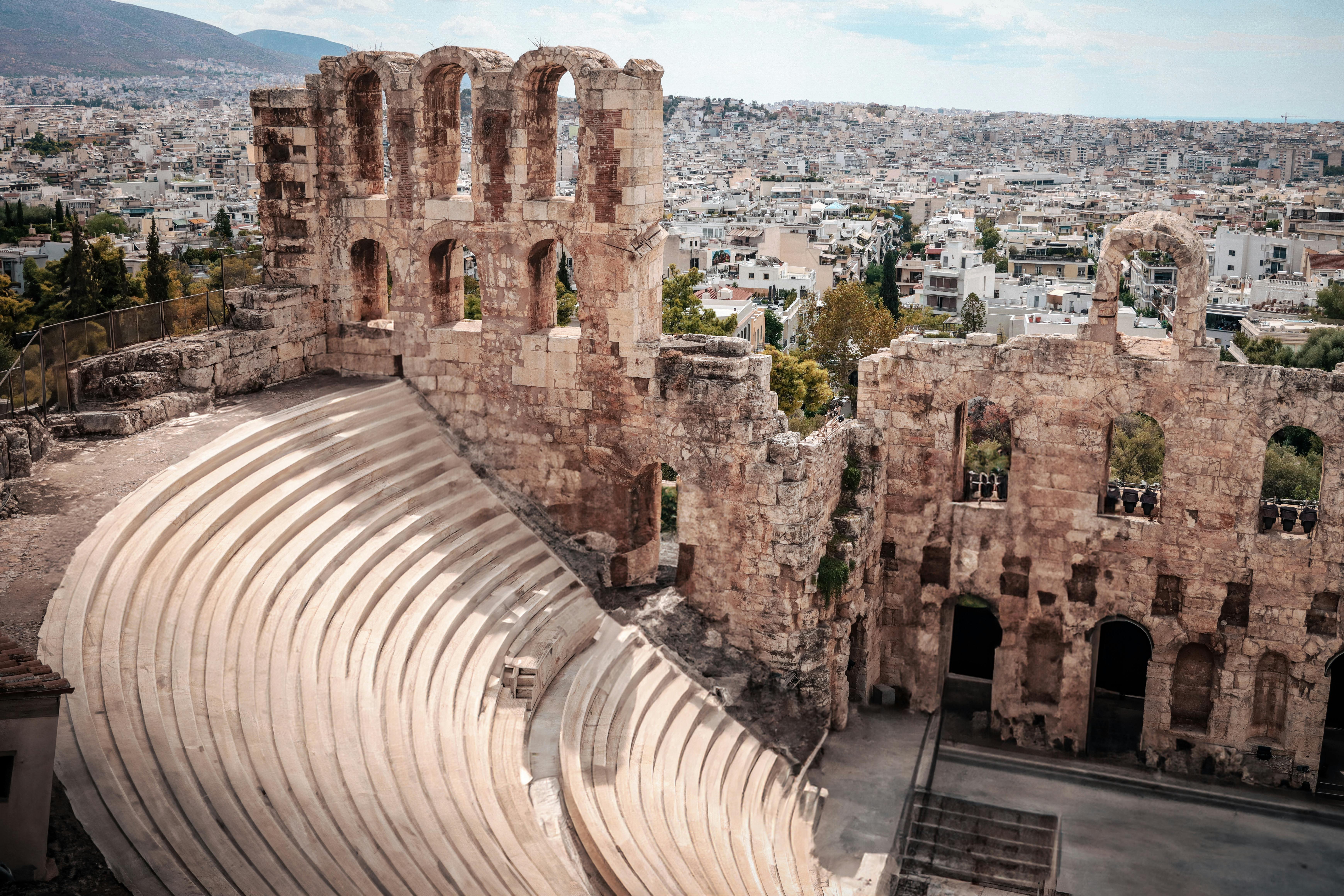 Athens at golden hour, the Acropolis above tiled rooftops with the city spreading out below — the topography that makes a Plaka, Koukaki, or Kolonaki base decisive for a slow-travel stay.