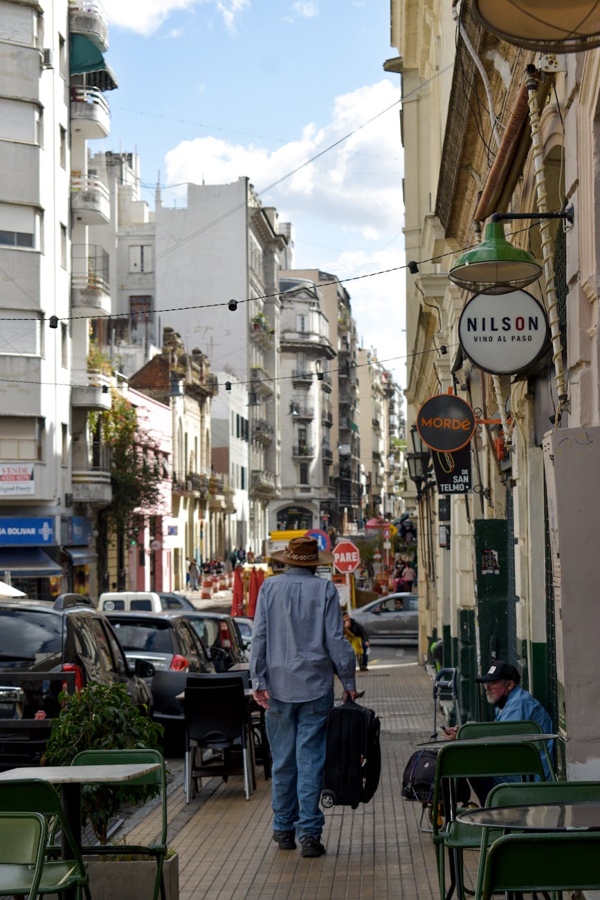 A Buenos Aires street in Palermo or Recoleta — jacaranda-lined sidewalks, Belle Époque facades, the urban scale that anchors a slow-travel stay.