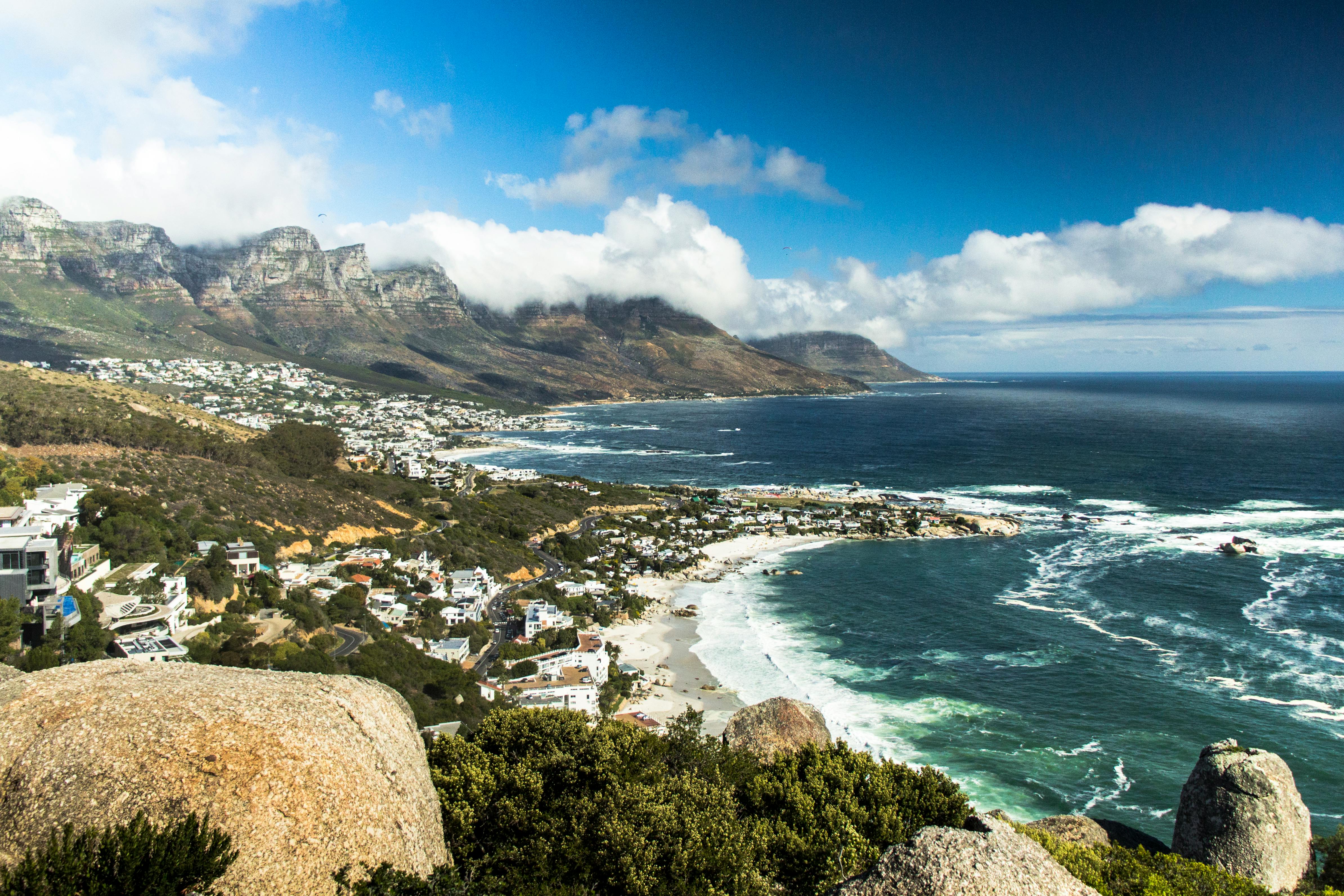 Cape Town with Table Mountain rising behind the city — the topography that anchors which neighborhood a slow-travel stay should choose.