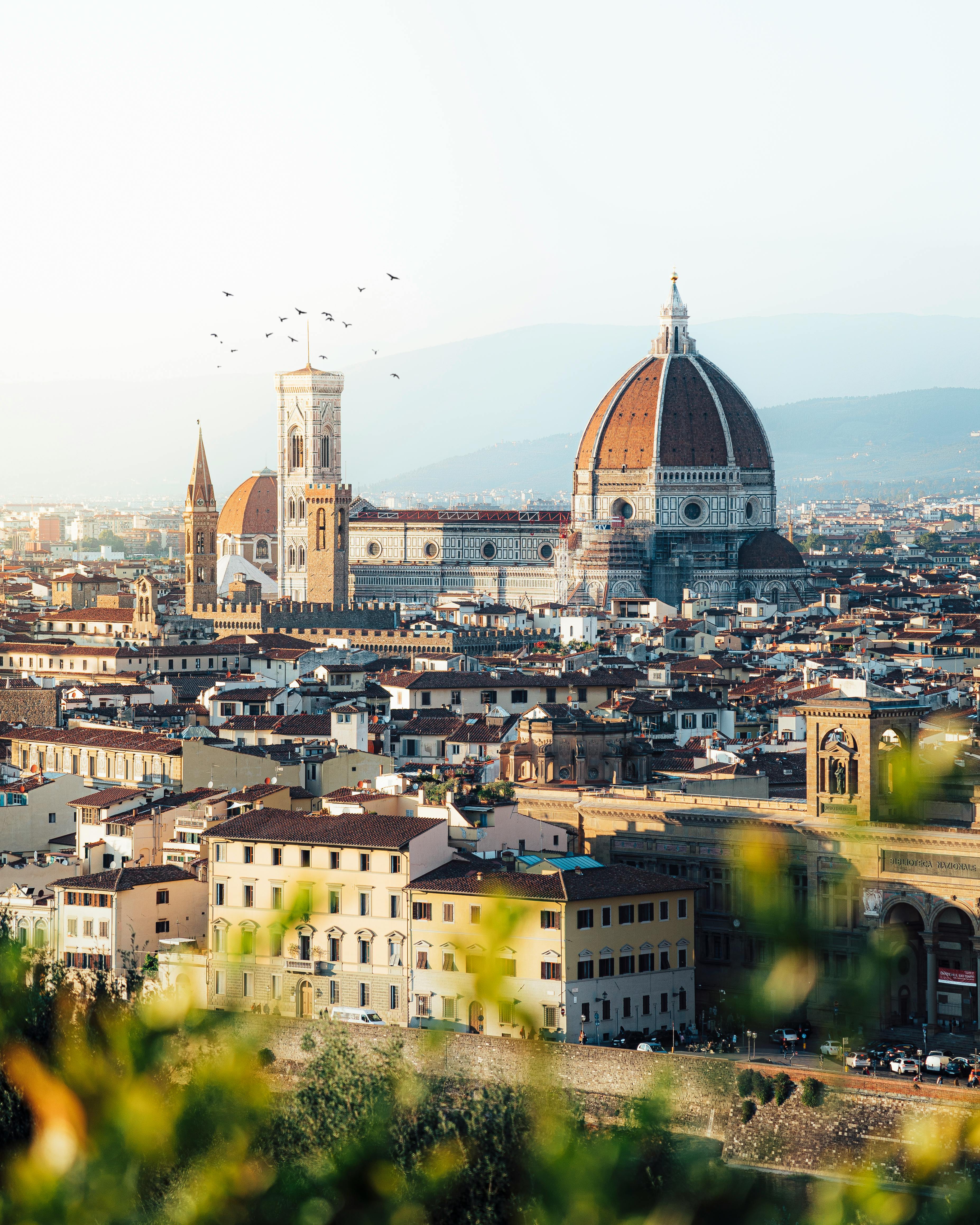 Florence rooftops and the Duomo of Santa Maria del Fiore — the city's compact, walkable scale that makes a slow-travel base credible at any of the five neighborhoods below.